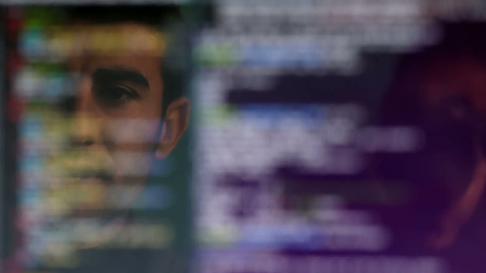 A face reflected in a screen filled with lines of text.